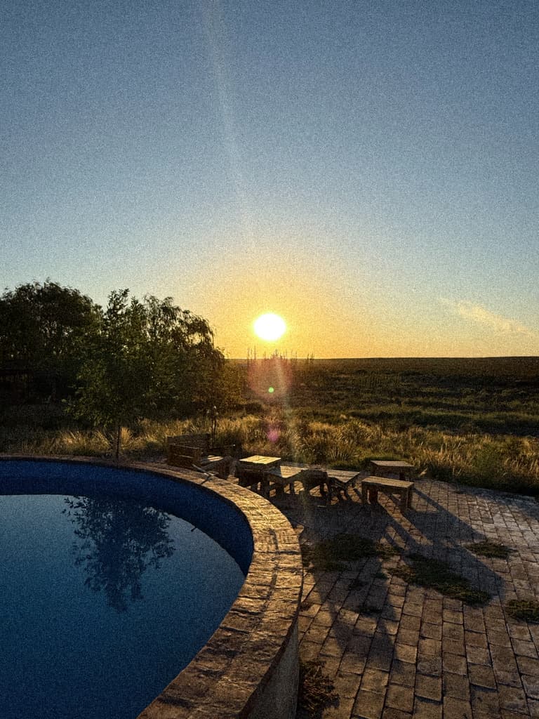 El sol se pone sobre la meseta, frente a la pileta media luna y sus bancos de madera.